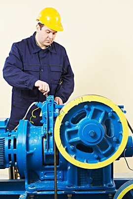 Mechaniker bei Wartungsarbeiten an einem Aufzugsmotor