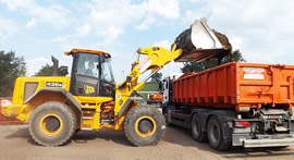 Erdaushube wird gesiebt mit gemiteter Siebmaschien und dann auf Laster verladen